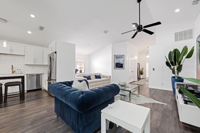 living room with vaulted ceiling, visible vents, dark wood finished floors, and recessed lighting