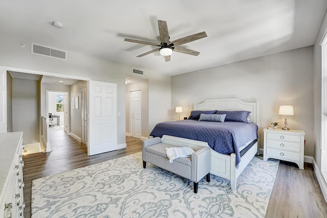 bedroom featuring baseboards, visible vents, and wood finished floors