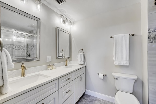 bathroom featuring double vanity, a sink, toilet, and a shower stall