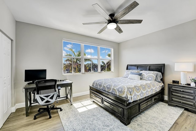 bedroom featuring light wood-style flooring, baseboards, and ceiling fan