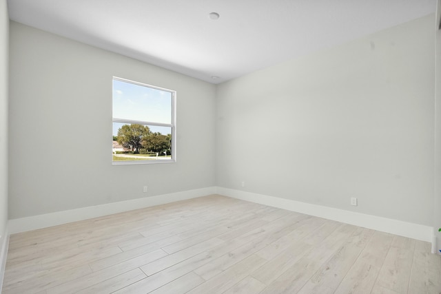 empty room with baseboards and wood finished floors