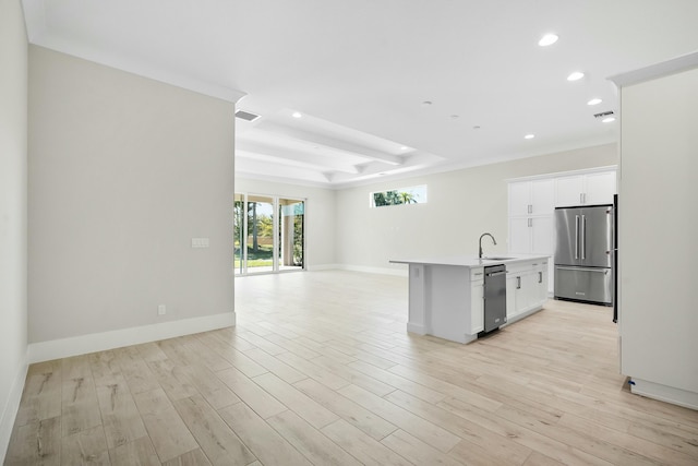 kitchen with stainless steel appliances, a raised ceiling, visible vents, open floor plan, and light wood-type flooring