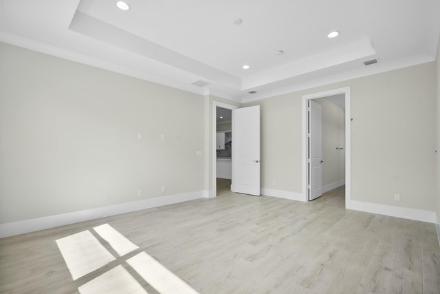 interior space with recessed lighting, baseboards, a spacious closet, light wood-type flooring, and a tray ceiling