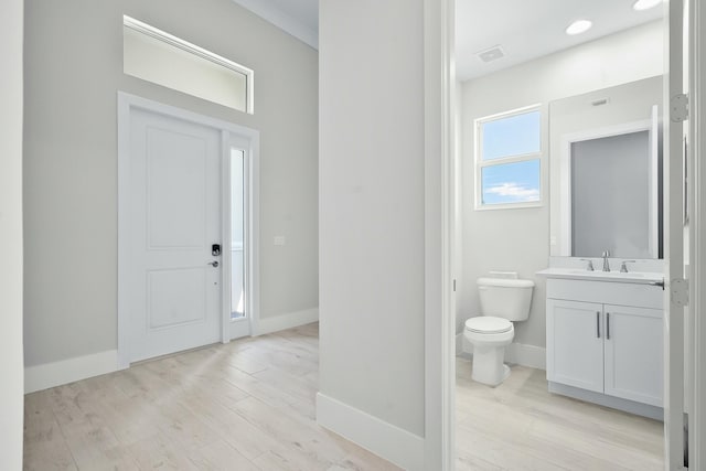 entrance foyer with visible vents, light wood-style flooring, and baseboards