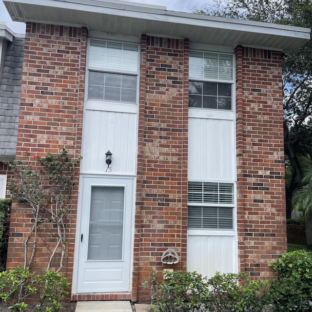 view of exterior entry featuring brick siding