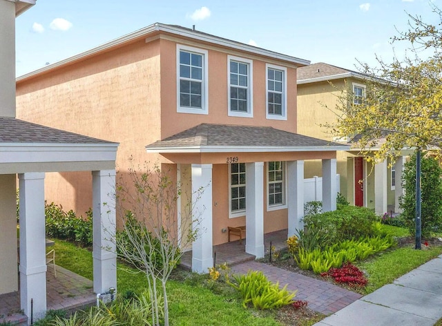 2349 SE Union Park Dr, Port Saint Lucie, FL 34952 - view of front facade with a porch, a shingled roof, and stucco siding