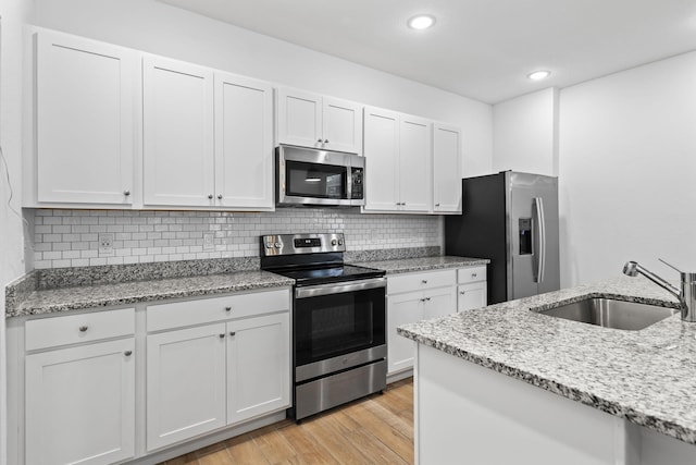 2349 SE Union Park Dr, Port Saint Lucie, FL 34952 - kitchen with light wood-style flooring, a sink, backsplash, and stainless steel appliances