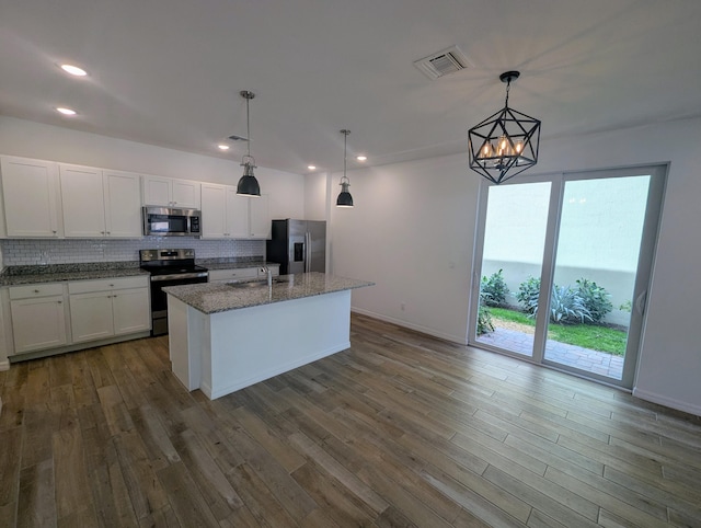 kitchen featuring stone countertops, dark wood-style floors, stainless steel appliances, white cabinetry, and backsplash