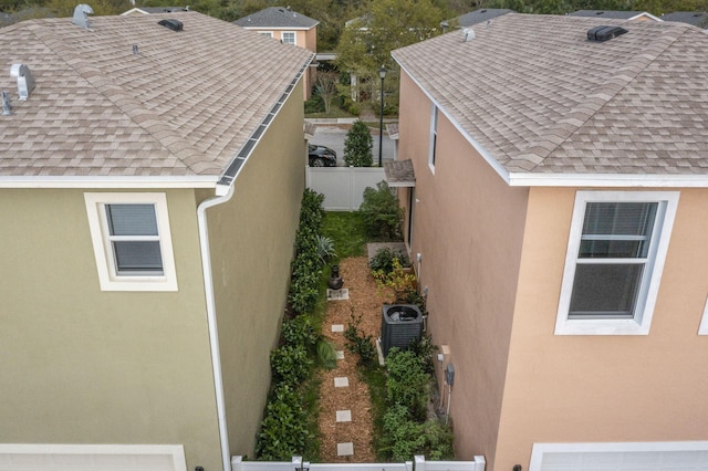 2349 SE Union Park Dr, Port Saint Lucie, FL 34952 - view of home's exterior with roof with shingles, stucco siding, and central AC unit