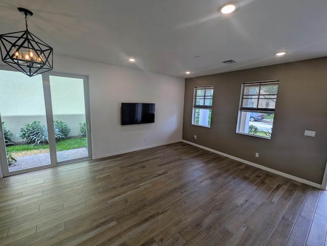 unfurnished living room with baseboards, visible vents, dark wood finished floors, and recessed lighting