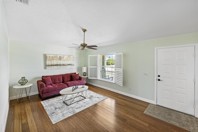 living room with a ceiling fan, wood finished floors, baseboards, and a textured ceiling