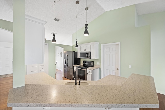 kitchen featuring dark wood finished floors, arched walkways, a sink, white cabinets, and appliances with stainless steel finishes