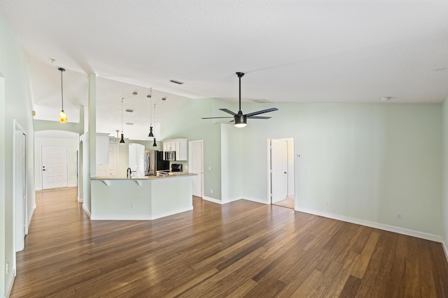 unfurnished living room featuring arched walkways, a ceiling fan, dark wood-style flooring, and baseboards