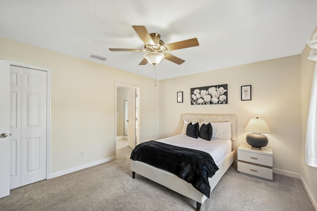 carpeted bedroom with a ceiling fan, baseboards, visible vents, and a closet