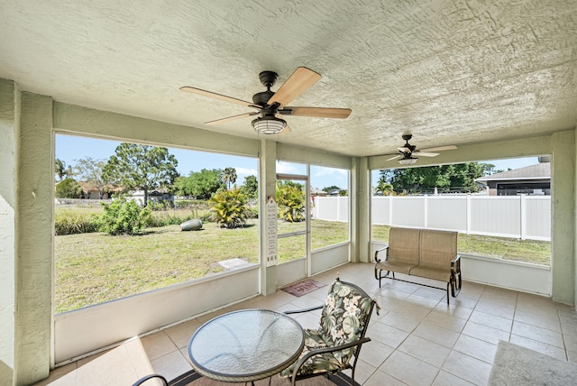 unfurnished sunroom with ceiling fan