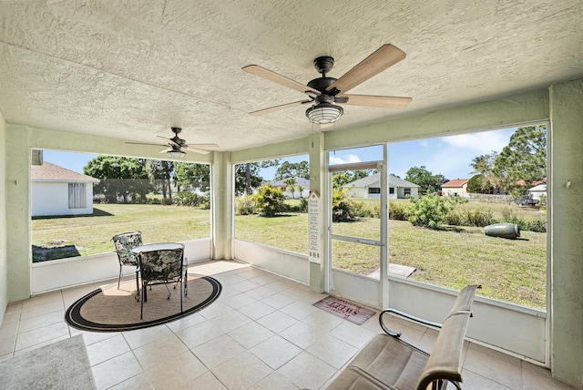 unfurnished sunroom featuring ceiling fan