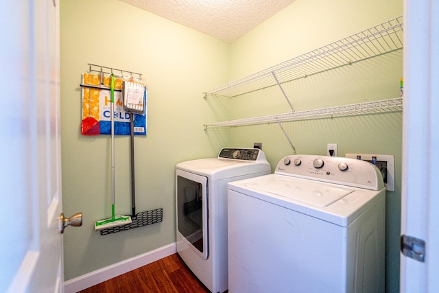 laundry room with baseboards, laundry area, dark wood-style floors, washer and dryer, and a textured ceiling