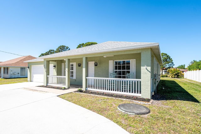 view of front facade with a front yard, driveway, a porch, an attached garage, and stucco siding