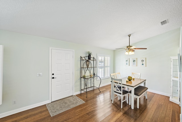 dining area with visible vents, a textured ceiling, baseboards, and hardwood / wood-style flooring