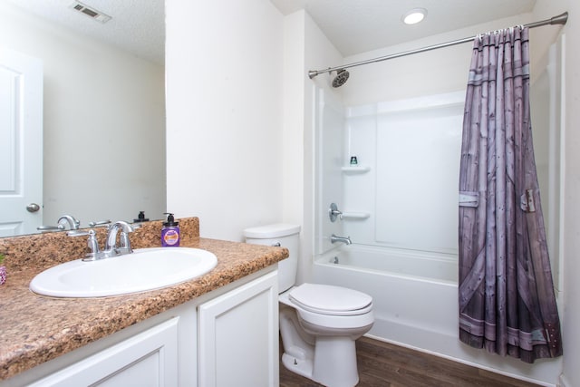 full bathroom with visible vents, toilet, wood finished floors, vanity, and shower / bath combination with curtain