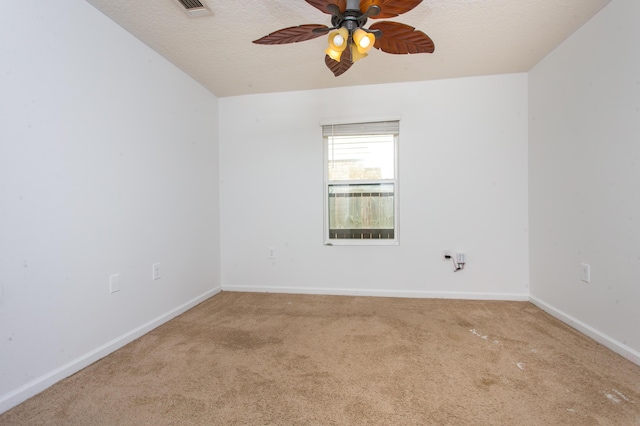 carpeted empty room featuring baseboards, visible vents, a textured ceiling, and a ceiling fan