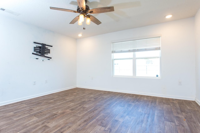 unfurnished room with baseboards, visible vents, wood finished floors, and a ceiling fan
