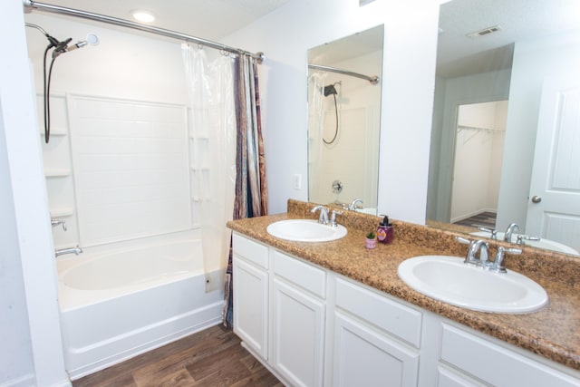 bathroom featuring visible vents, a sink, shower / tub combo, and wood finished floors