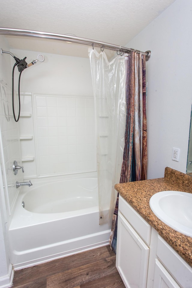 full bath featuring shower / tub combo with curtain, a textured ceiling, wood finished floors, and vanity