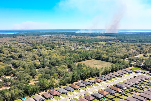bird's eye view with a water view, a view of trees, and a residential view