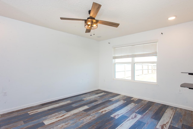 spare room featuring wood finished floors, a textured ceiling, baseboards, and ceiling fan