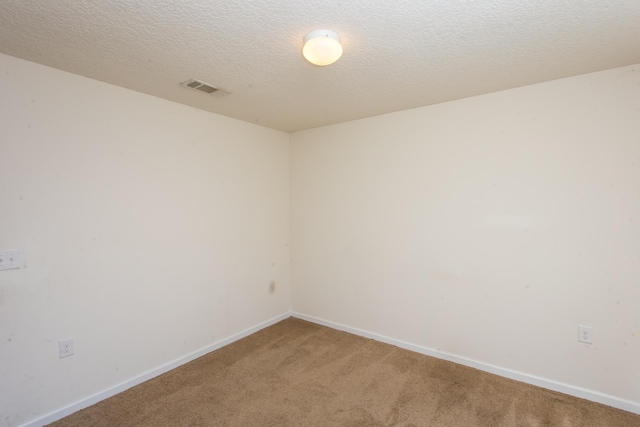 spare room with baseboards, light colored carpet, and visible vents