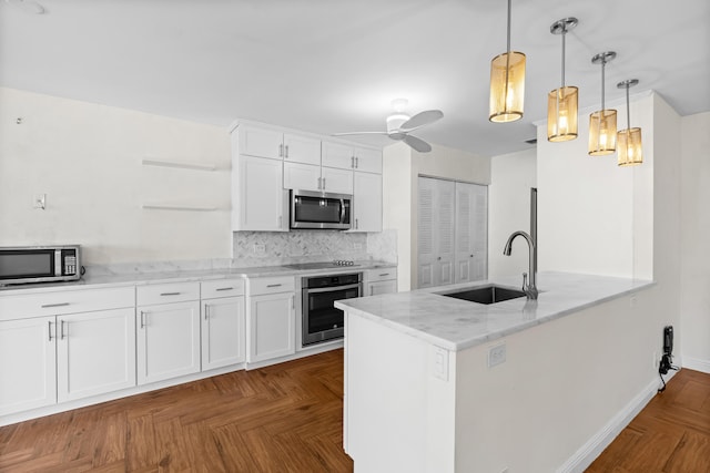 kitchen featuring a sink, light stone counters, white cabinetry, stainless steel appliances, and decorative backsplash