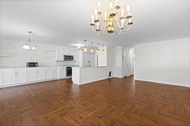 unfurnished living room featuring a notable chandelier, baseboards, and a sink