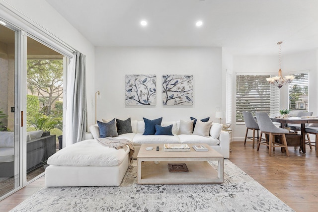 living room with a notable chandelier, wood finished floors, and recessed lighting