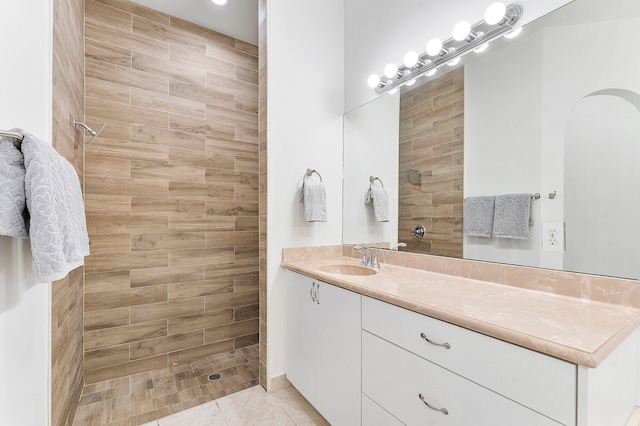 bathroom featuring vanity, a tile shower, and tile patterned floors