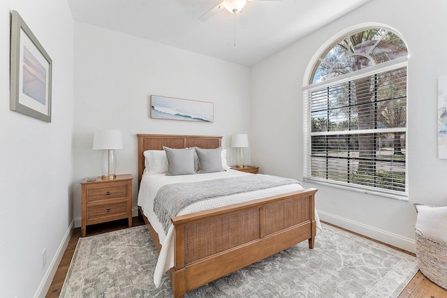 bedroom with ceiling fan, baseboards, and wood finished floors