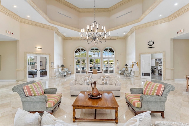 living area with a chandelier, marble finish floor, ornamental molding, and baseboards