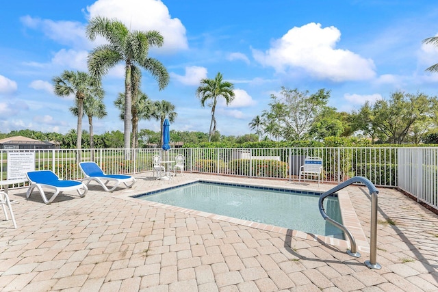 view of swimming pool with fence, a pool, and a patio