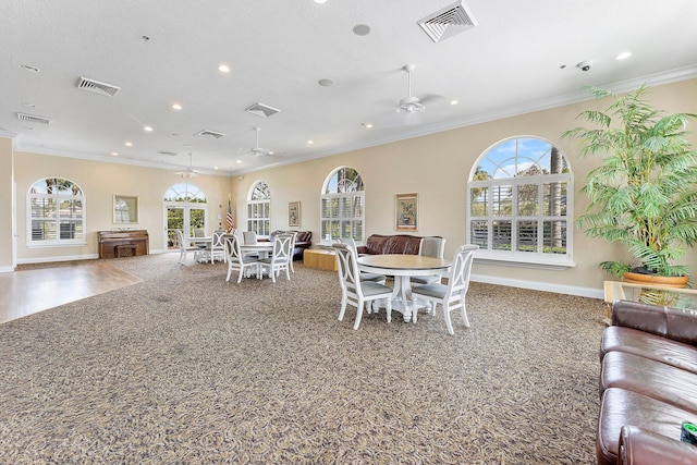 dining area with visible vents, a ceiling fan, and ornamental molding