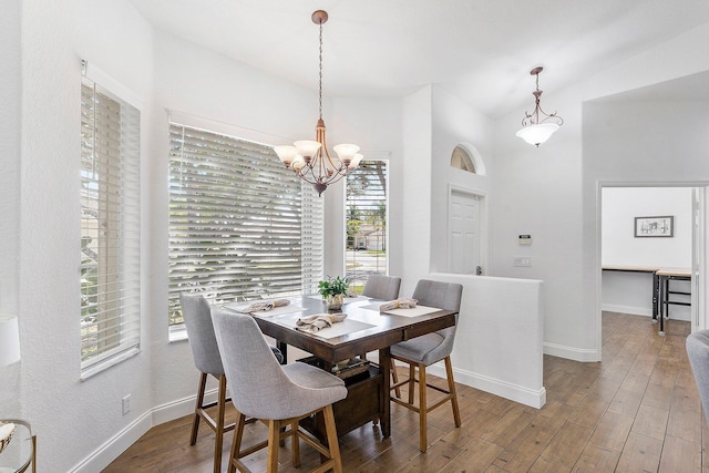 dining area with an inviting chandelier, baseboards, and wood finished floors