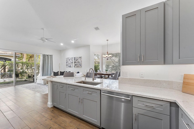 kitchen with a peninsula, a sink, open floor plan, gray cabinets, and dishwasher