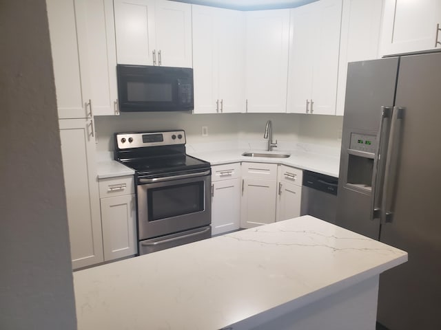 kitchen featuring appliances with stainless steel finishes, white cabinets, and a sink