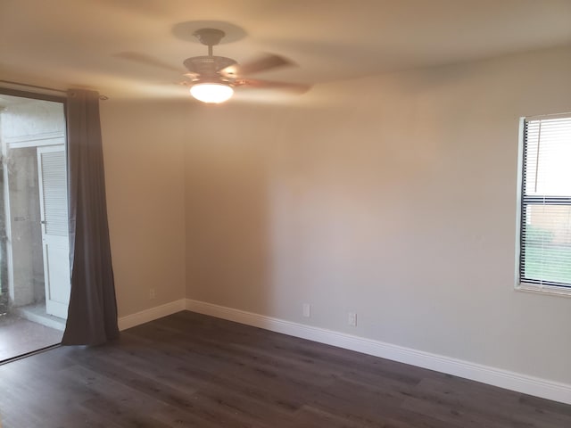 spare room with a ceiling fan, dark wood-style flooring, and baseboards