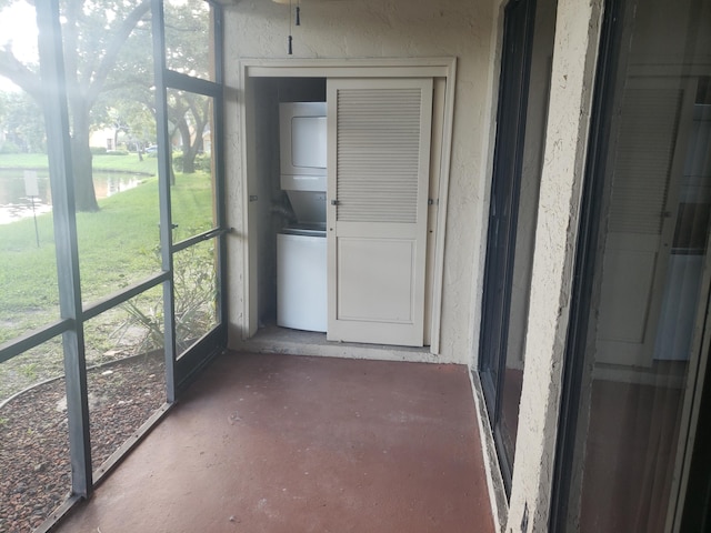 unfurnished sunroom with stacked washing maching and dryer