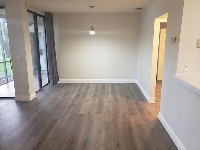 unfurnished dining area featuring baseboards, floor to ceiling windows, visible vents, and wood finished floors