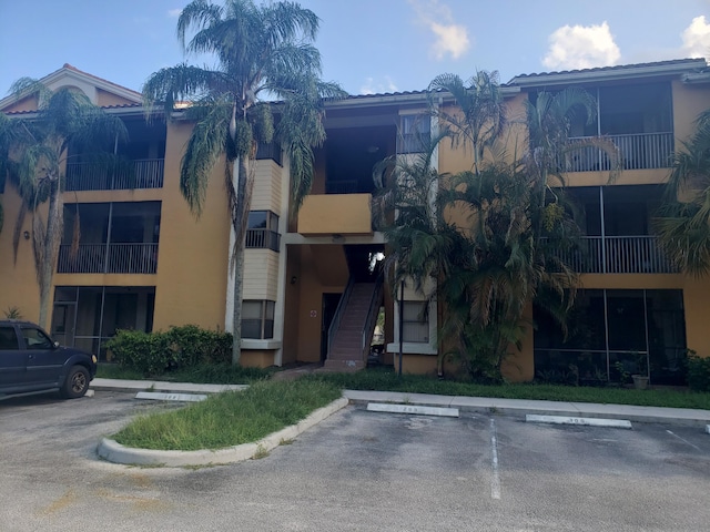 view of building exterior featuring uncovered parking and stairway