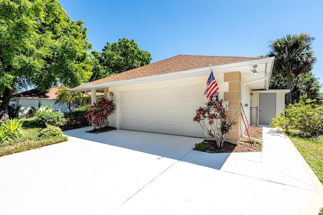 view of front of house featuring a garage, roof with shingles, concrete driveway, and stucco siding