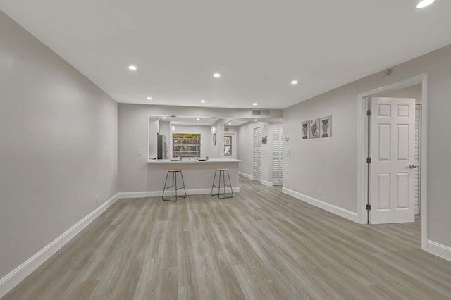 unfurnished living room with light wood-style flooring, visible vents, baseboards, and recessed lighting