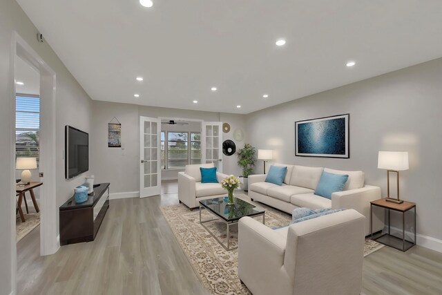 kitchen with a peninsula, a sink, stainless steel appliances, white cabinetry, and backsplash