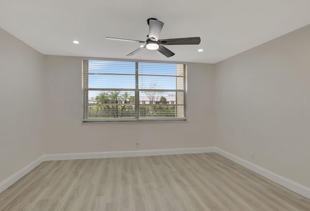 spare room featuring light wood-style floors, baseboards, a ceiling fan, and recessed lighting